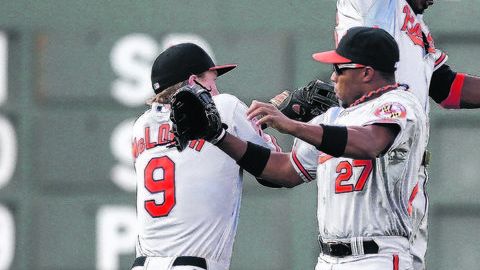 Nate McLouth (izq.), Endy Chávez (27) y Adam Jones celebran al caer el último out del partido que los mantiene rumbo a los playoffs.