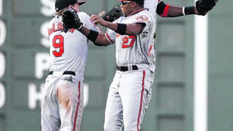 Nate McLouth (izq.), Endy Chávez (27) y Adam Jones celebran al caer el último out del partido que los mantiene rumbo a los playoffs.
