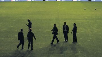 El cuerpo técnico del Real Madrid camina en la cancha del Teresa Rivero al suspenderse el juego.