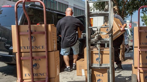 Agentes federales transportan  las evidencias obtenidas en un operativo realizado en el área de Chinatown, en Los Ángeles.