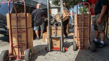 Agentes federales transportan  las evidencias obtenidas en un operativo realizado en el área de Chinatown, en Los Ángeles.