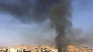 Una columna de humo que se eleva sobre el centro de Damasco tras registrarse dos fuertes explosiones, Siria.
