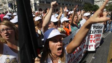 Un gran grupo de personas grita consignas en una manifestación en Atenas, con motivo de la huelga general de 24 horas  que vivió Grecia, el desafío más reciente para el Gobierno, ayer.
