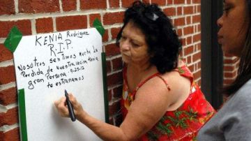 Iris Arroyo, vecina de Kenia Rodríguez, escribe un mensaje por la muerte de su amiga, Kenia Castillo-Reyes, en el lugar donde se produjo el asesinato.