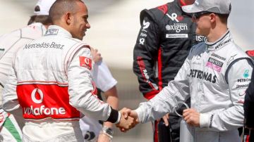 Lewis Hamilton (izq.) saluda a Michael Schumacher, a quien reemplazará la próxima temporada en Mercedes.
