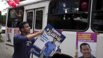 Un simpatizante de Capriles carga un cartel en apoyo al candidato.