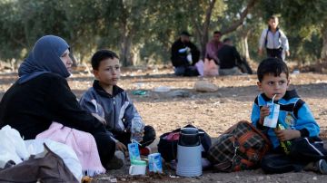 Familias sirias descansan después de cruzar la frontera desde Tal Shehab en Siria, a traves del valle de Al Yarmouk River, hasta Ramtha, Jordania.