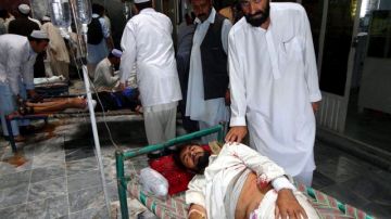 Afganos que resultaron heridos en el atentado suicida perpetrado contra un convoy de la misión de la OTAN.