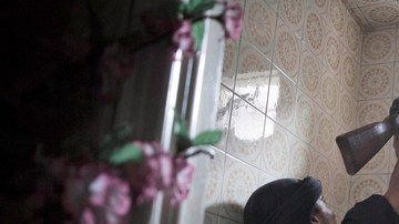 Un insurgente buscaba ayer desde una ventana a militares del régimen de al Asad, con quienes se mantiene una reñida batalla.