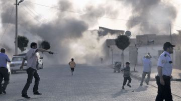 Ciudadanos turcos escapan del humo provocado por una bomba de mortero lanzada desde Siria, en Sanliurfa, Turquía, ayer.