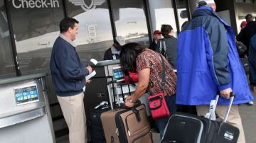En la imagen, pasajeros que pasan la línea de revisión del Aeropuerto Internacional de Los Ángeles.