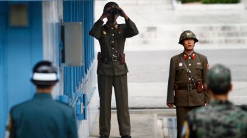 Soldados norcoreanos (de espaldas) y surcoreanos permanecen en guardia sobre la línea fronteriza que divide a las dos 'Coreas'.