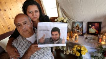 Don Leonel Escobar, acompañado de su hija Ana Escobar, muestra la foto de su hijo  fallecido.