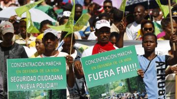 Miembros de organizaciones comunitarias y sindicales marchan hoy en contra de la propuesta de reforma fiscal que propone el gobierno en Santo Domingo.