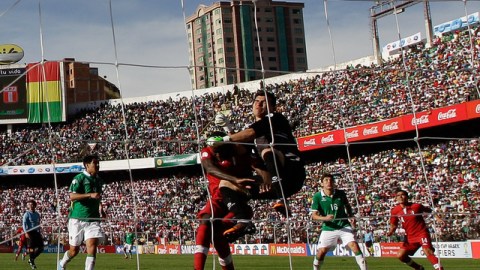 El peruano Christian Ramos pelea una pelota con el portero de la selección de Bolivia, Hugo Suárez, en el choque disputado en La Paz.