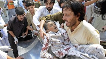 Un niño herido era trasladado ayer a un hospital tras la explosión ocurrida  en el Bazar Darra Adam Jel, en Pakistán.