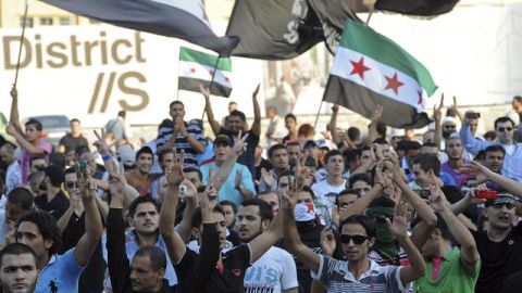 Manifestantes ondean banderas y gritan consignas  contra el régimen de Siria en la Plaza de los Mártires en Beirut, Líbano, ayer.