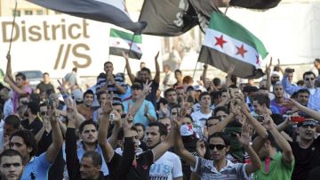 Manifestantes ondean banderas y gritan consignas  contra el régimen de Siria en la Plaza de los Mártires en Beirut, Líbano, ayer.