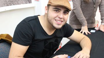 Gerardo Ortiz, cantautor mexicano, firma el sombrero de Jesse Barraza, de cuatro años, en el barrio de La Villita, en Chicago.