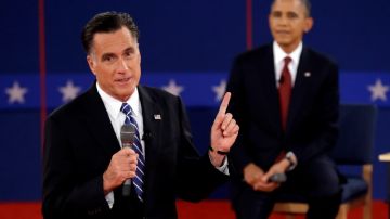 Mitt Romney (al frente) y el presidente Obama (atrás)  durante el segundo debate celebrado ayer en la Universidad de Hofstra.