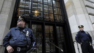 Policías  vigilan  frente al Banco de la Reserva Federal, en Nueva York, el edificio amenazado por un individuo que intentaba volarlo.