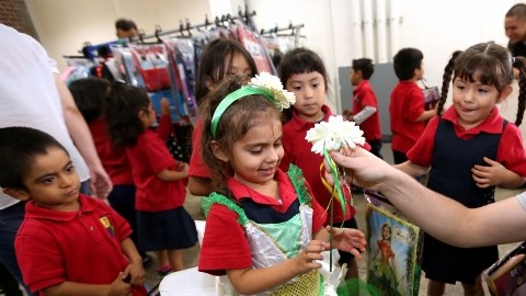 Estudiantes de Kinder escogen sus disfraces de Halloween entre los muchos que les fue llevado.