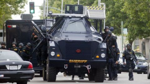 Policías especializados realizan la búsqueda de un hombre armado en el campus de una universidad en Oakland, California.