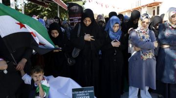 Varias mujeres turcas rezan durante una protesta contra el presidente sirio, Bachar al Asad, tras asistir a las oraciones musulmanas de los viernes en Estambul, Turquía, ayer.