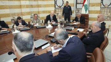 Michel Suleiman (5º izq.) dirige, junto al primer ministro, Nayib Mikati (4º izq.), la reunión urgente celebrada por el Gobierno libanés, ayer.