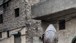 Un miembro del ejército rebelde muestra su armamento en una de las derruidas calles de Alepo, otra de las ciudades más castigadas por los bombardeos de las fuerzas del Gobierno.