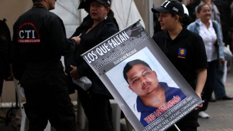 Una detective del cuerpo técnico de investigaciones de la fiscalía (CTI), de Colombia, lleva el retrato de una víctima que está secuestrada.
