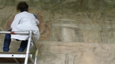 Una trabajadora del Getty Conservation Institute restaurando  el área central del polémico mural que ya está abierto al público.