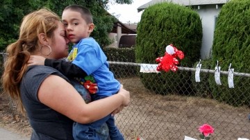 Stephanie Venegas con su hijo Nathan frente al altar  para las víctimas. Nathan y el niño fallecido eran compañeros de escuela.