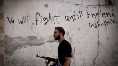Un rebelde sirio camina por Alepo, en Syria. Los combates continúan cobrando vidas en la región.