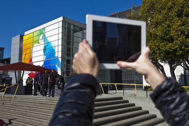 Una persona toma fotos con su iPad al logotipo de Apple impreso en el centro de Yerba Buena en San Francisco, California.