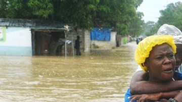 Dos mujeres caminan por una calle inundada  en el municipio de Cité Soleil, en Puerto Príncipe, Haití, donde se registran 29 muertes.