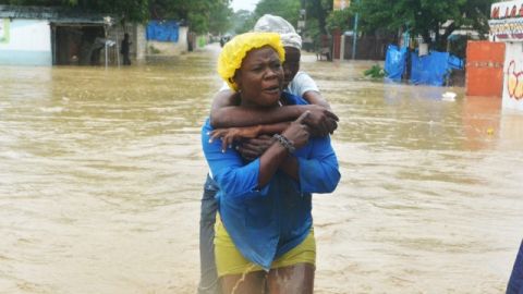 Dos mujeres caminan por una calle inundada  en el municipio de Cité Soleil, en Puerto Príncipe, Haití, donde se registran 29 muertes.