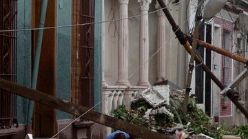 Residentes caminan por sobre los escombros de las casas que fueron dañadas por el huracán Sandy en Santiago de Cuba, el viernes.
