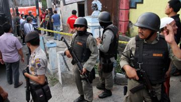 Agentes de la Policia indonesia hacen guardia a las afueras de un edificio tras una redada antiterrorista en ese país.