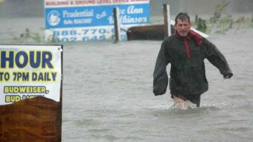 Después de comprobar que su barco está seguro, Bob Casseday cruza la calle inundada de Savannah Road en Lewes, Delaware, para volver a casa, bajo la lluvia de la supertormenta "Sandy".