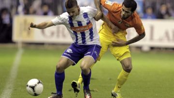 El defensa brasileño Dani Alves, del Barcelona, disputa un balón con Asier Barahona, del Alavés
