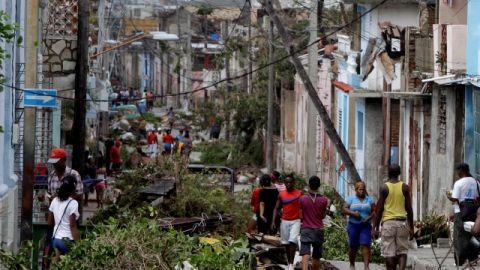 En  Santiago de Cuba caminan sobre ramas de árboles y las líneas de energía caídas por 'Sandy'.