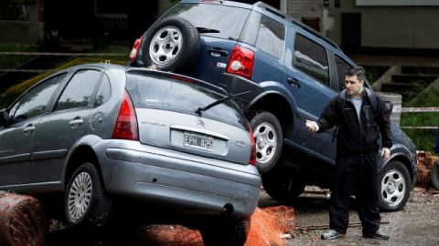 Un hombre observa los daños a carros apilados por las inundaciones en Buenos Aires, ayer, debido a las fuertes lluvias.