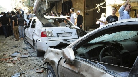 Varias personas alrededor del lugar donde se ha producido la explosión de un coche-bomba en Yaramana, al sur de Damasco, en Siria, ayer.