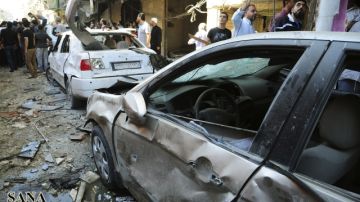 Varias personas alrededor del lugar donde se ha producido la explosión de un coche-bomba en Yaramana, al sur de Damasco, en Siria, ayer.