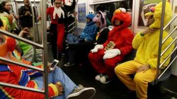 Grupo de amigos vestidos como personajes de Sesame Street, en NY, ayer. Festividades se habían  suspendido a causa de  tormenta.