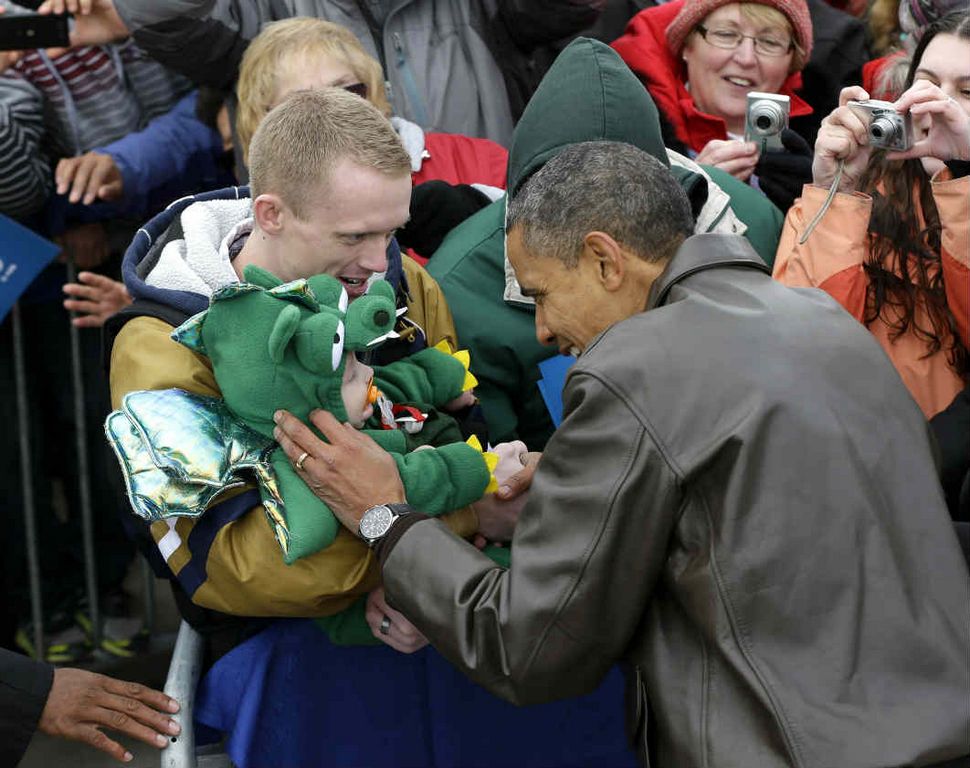 El Presidente Barack Obama se detiene a saludar a un niñito disfrazado durante un acto de campaña en Green Bay, Wisconsin el 1o. de noviembre de 2012.