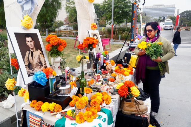 La artista Pocha Peña, prepara un altar para la celebración en el parque.