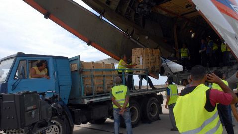 Trabajadores cubanos descargan paquetes de ayuda humanitaria.