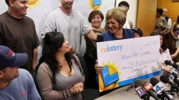 Julie Cervera rodeada de sus familiares, recibe un cheque simbólico por 23 millones de dólares de la Lotería de California.